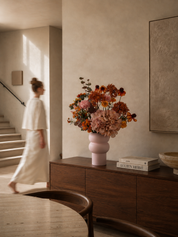 Amber Blush zijden boeket in warme tinten op een walnoot dressoir in modern interieur