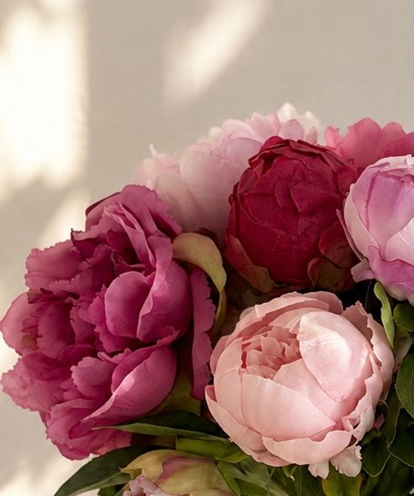 Zijden pioenrozen boeket in roze tinten volle en gesloten bloemen met vaas