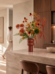 Burnt Orange zijden boeket in warme oranje en roesttinten met terracotta vaas