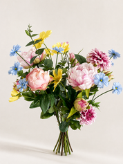 Zijden boeket met pioenrozen en bloemen in pastel geel, blauw en roze op lichte achtergrond
