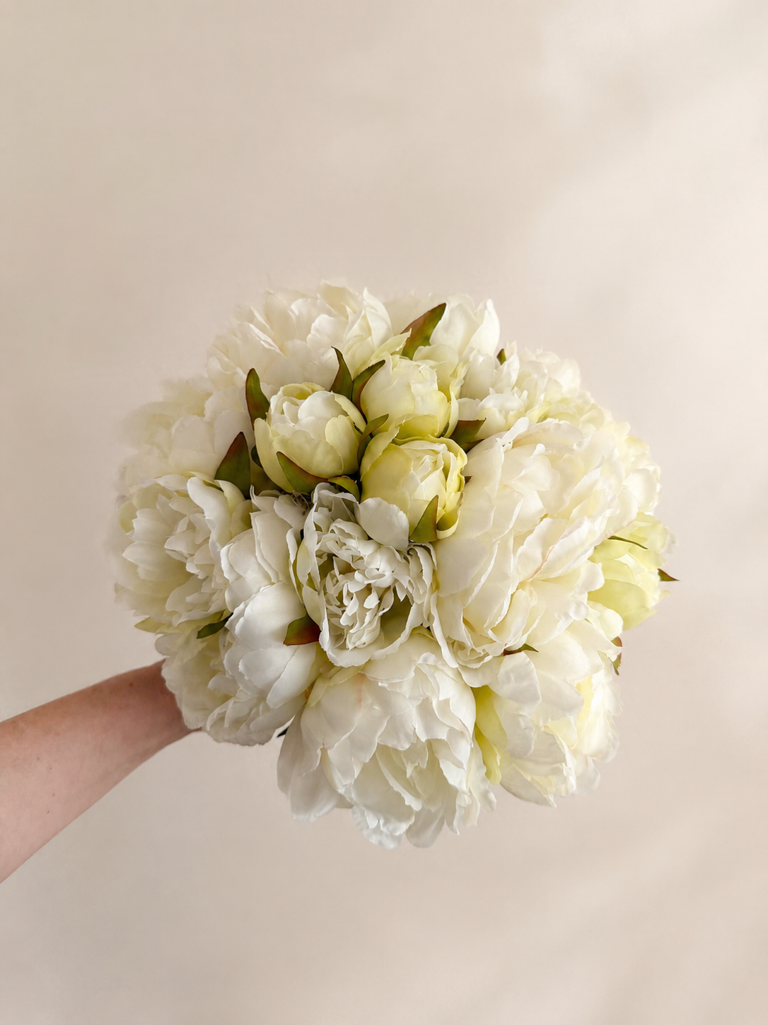 Zijden pioenrozen boeket in zacht crème en wit met volle bloemen op lichte achtergrond