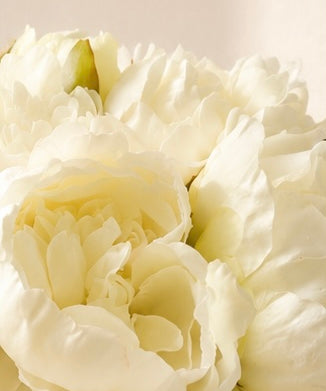 Zijden pioenrozen boeket in zacht crème en wit met volle bloemen op lichte achtergrond